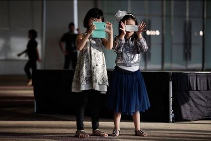 Des filles jouent avec leur téléphone à Bangkok, en Thaïlande, le 10 novembre 2013.