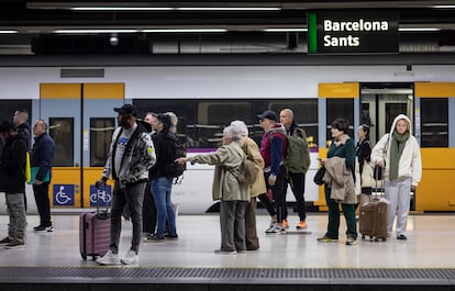 Les usagers attendent le départ d'un train sur le quai de la gare de Sants à Barcelone.