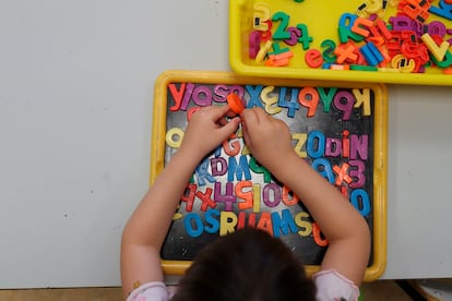 Un enfant joue avec des lettres magnétiques pendant un cours dans une école de Madrid. 
