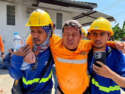 Deux travailleurs aident les blessés lors du tremblement de terre, à Bangkok.