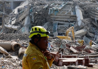 Le personnel de sauvetage travaille parmi les débris d'un bâtiment en construction derrière le tremblement de terre à Bangkok.