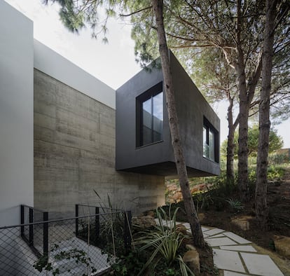 La façade a des volumes intégrés dans la forêt de pin.