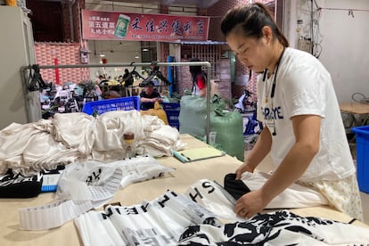 Une femme pacie des vêtements pour la marque Shein dans une usine de Nancun, une ville de Guangzhou (province de Canton, au sud de la Chine) connu sous le nom de Shein People, pour le nombre d'ateliers textiles qui produisent pour cette marque, le mercredi 16 avril.