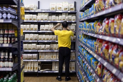 Dans l'image, un dépendant ordonne une étagère avec différents types de pâtes dans l'un des magasins Casa Italia, à Barcelone.