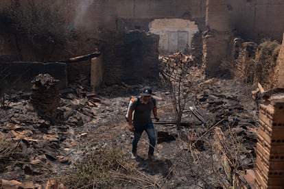 Un voisin de Congosto éteint les braises de l'incendie qui ont brûlé plusieurs maisons dans la ville léonaise.