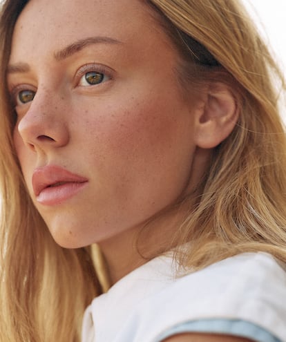 L'actrice avec un haut blanc et bleu clair d'Issey Miyake.