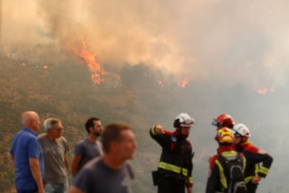 Plusieurs personnes observent le feu de la forêt, le 24 août, à La Baña (León).